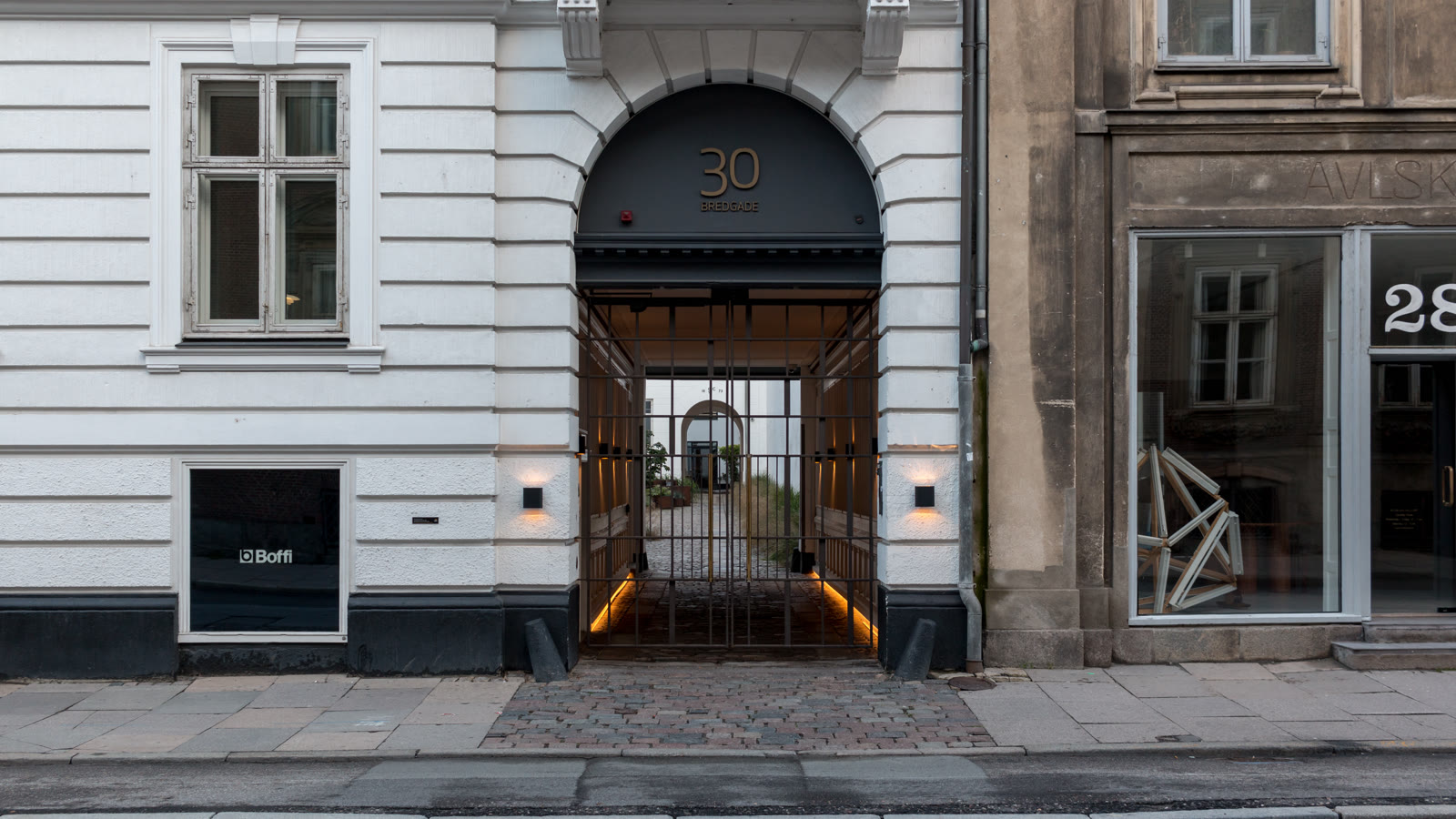 Portrummet i Bredgade 30 med husnummeret i guld over porten og en designbutik ved siden af